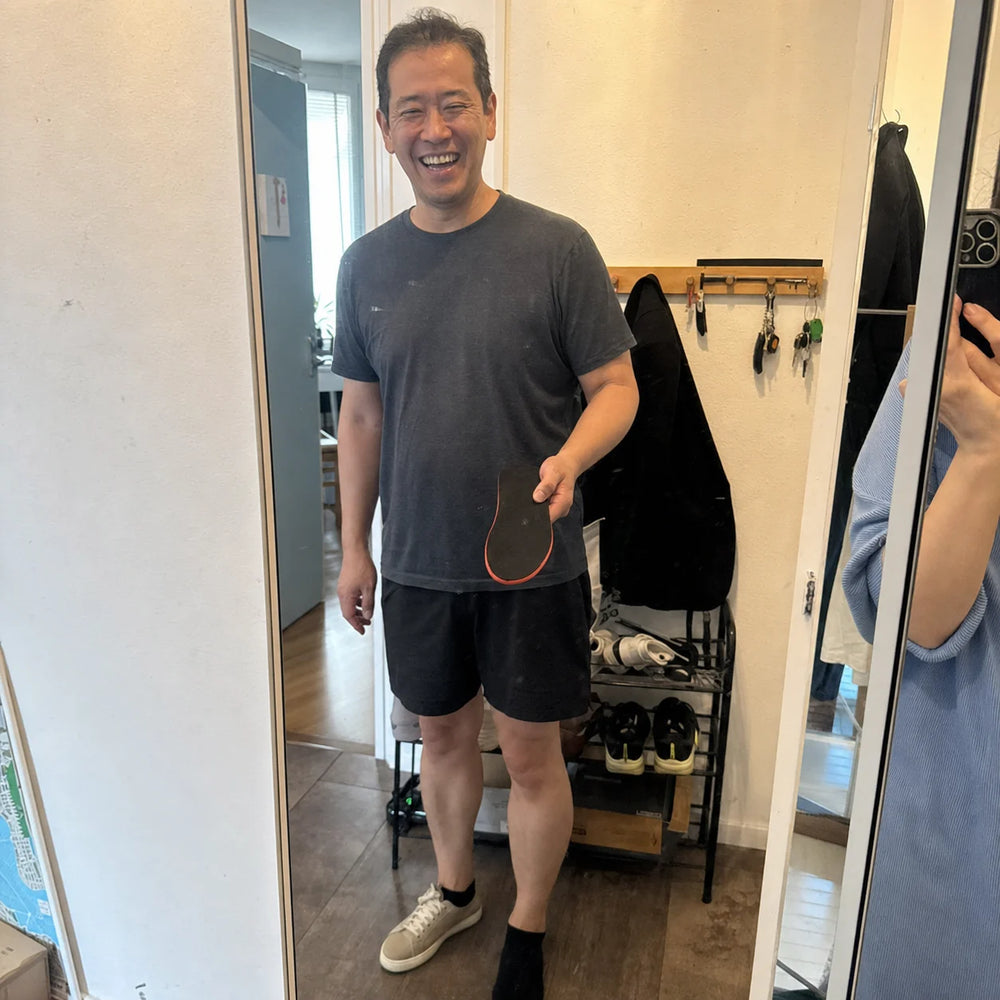 Peter smiling in his hallway while holding an Ortavio ArcCore insole